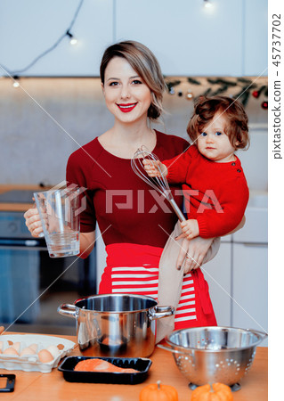 housewife with baby boy preparing Christmas dinner housewife with baby boy preparing Christmas dinner 45737702