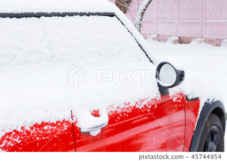 Red car covered after snowfall 45744954