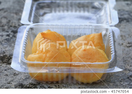 close up cream puffs in box plastic on cement close up cream puffs in box plastic on cement 45747054
