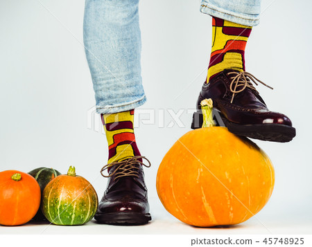 Beautiful pumpkins and men's legs in stylish shoes Beautiful pumpkins and men's legs in stylish shoes 45748925
