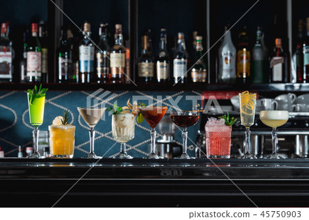 row of various colourfull alcoholic cocktails on a bar desk. Glasses of differen shapes 45750903