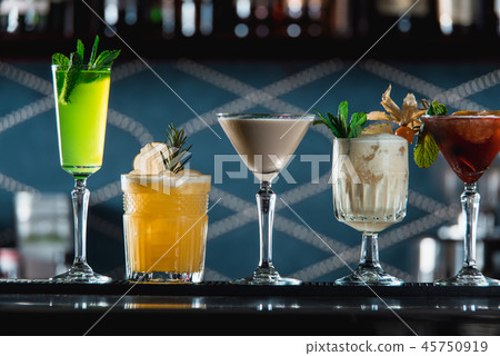 row of various colourfull alcoholic cocktails on a bar desk. Glasses of differen shapes 45750919