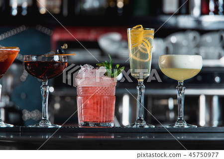 row of various colourfull alcoholic cocktails on a bar desk. Glasses of differen shapes 45750977