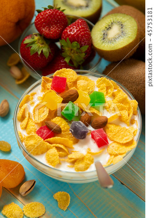 Tasty cornflakes with milk and fruits  in glass bowl  45753181