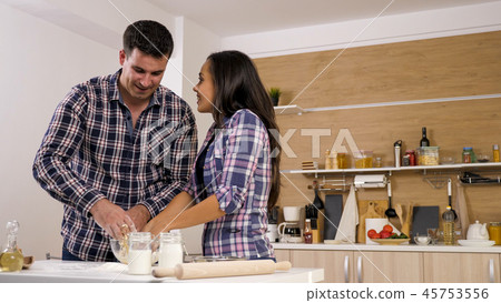 Couple cooking together in the kitchen at home Couple cooking together in the kitchen at home 45753556