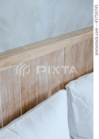 Wooden bedhead and gray concrete wall 45758745