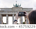 Hands holding phone mobile and takes pictures of Brandenburg Gat 45759229