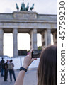 Hands holding phone mobile and takes pictures of Brandenburg Gat 45759230