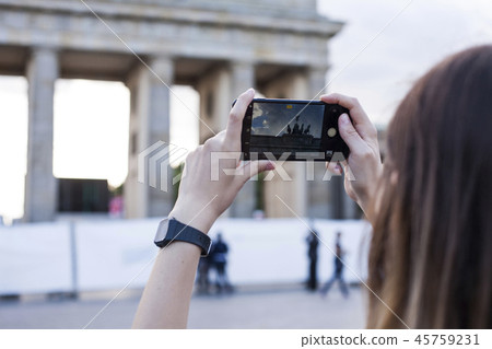 Hands holding phone mobile and takes pictures of Brandenburg Gat Hands holding phone mobile and takes pictures of Brandenburg Gat 45759231
