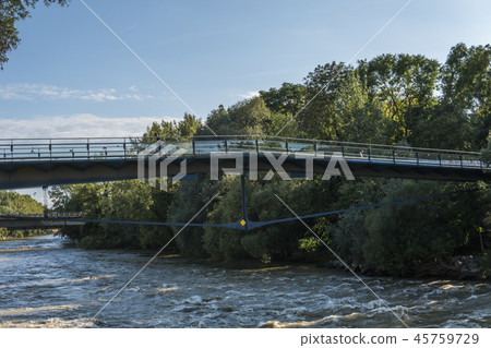 Pedestrian bridge over the stormy river in the evening Pedestrian bridge over the stormy river in the evening 45759729