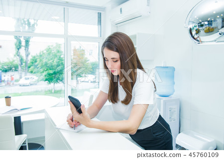 Young caucasian female receptionist with phone 45760109