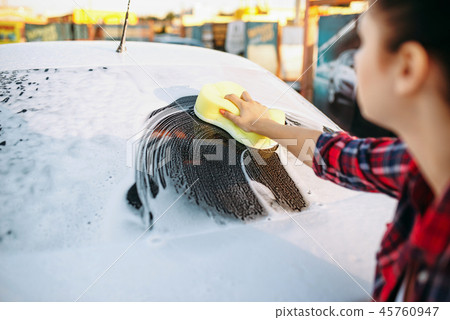 Young woman scrubbing vehicle glass with foam Young woman scrubbing vehicle glass with foam 45760947