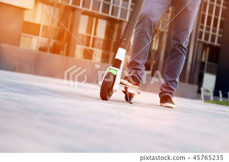 Close up image of a man on an electric scooter. 45765235