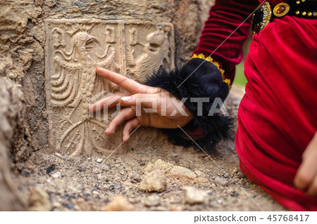 lady in historic dress beside heraldic sign carved in stone. lady in historic dress beside heraldic sign carved in stone. 45768417