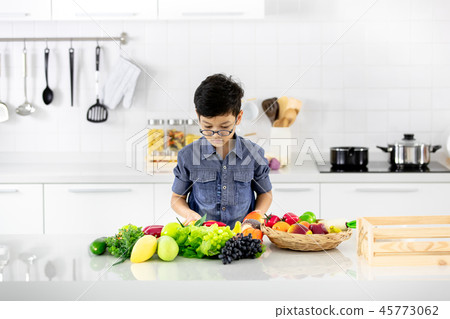 Boy in bright modern kitchen. Boy in bright modern kitchen. 45773062