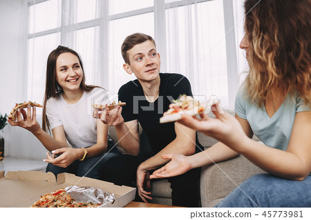 friends eating pizza and talking at home party 45773981