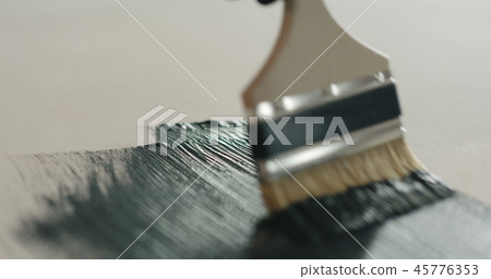 Brush painting plywood with black paint Brush painting plywood with black paint 45776353