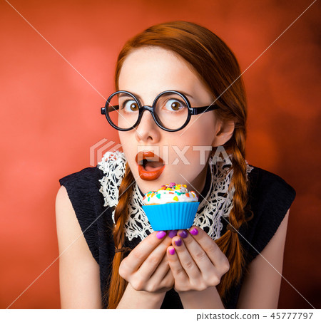 girl in glasses with two pigtails holding cupcake girl in glasses with two pigtails holding cupcake 45777797