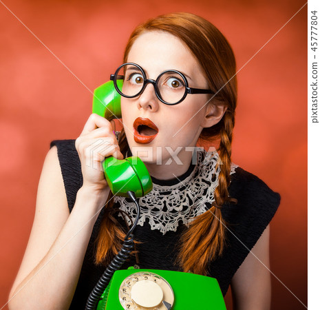 girl in glasses with two pigtails holding handset girl in glasses with two pigtails holding handset 45777804