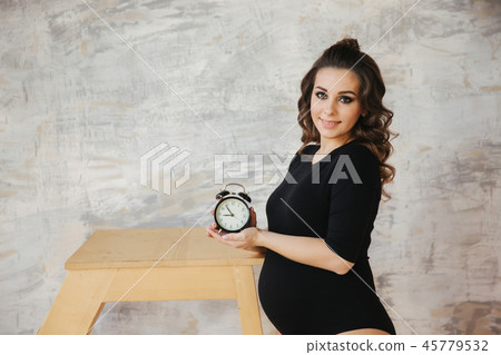 Portrait of beautiful future mom. Charming pregmant moman stand near the stairs and hilding an old Portrait of beautiful future mom. Charming pregmant moman stand near the stairs and hilding an old 45779532