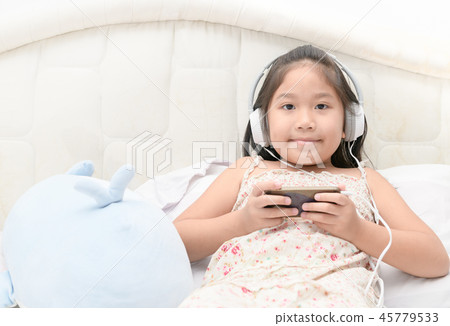 child girl listening to music from smartphone. child girl listening to music from smartphone. 45779533