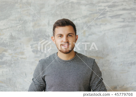 Handsome man with beard stand on the gray background in studio. He smile to camera Handsome man with beard stand on the gray background in studio. He smile to camera 45779708