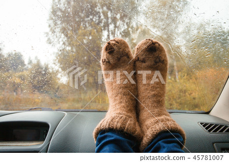 Woman legs in warm cute socks on car  45781007