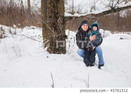 Dad and son in the winter forest. 45781312