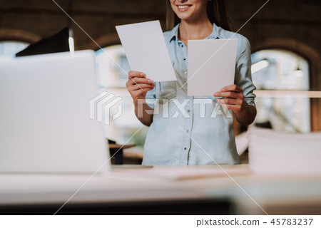 Charming girl holding two blank paper cards and smiling Charming girl holding two blank paper cards and smiling 45783237