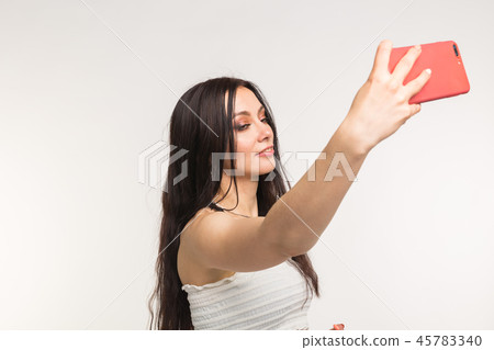 Happy european female model with dark hair enjoying indoor photoshoot. Young woman is taking a Happy european female model with dark hair enjoying indoor photoshoot. Young woman is taking a 45783340