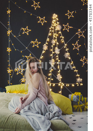 young woman in a plaid posing against the background of Christmas garlands. young woman in a plaid posing against the background of Christmas garlands. 45783344