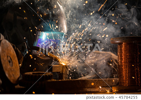 Welder is welding metal part in factory 45784255