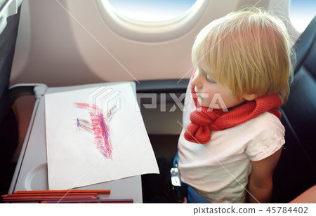 Little boy sitting by aircraft window 45784402