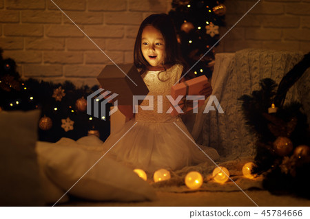 Pretty smiling girl holding Christmas gift in hand 45784666