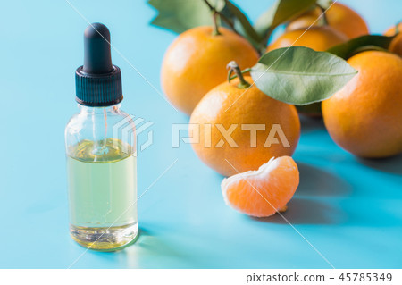 Essential oil of orange mandarin on blue. 45785349
