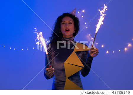 Portrait of young woman celebrating holding sparkle stick. Portrait of young woman celebrating holding sparkle stick. 45786149