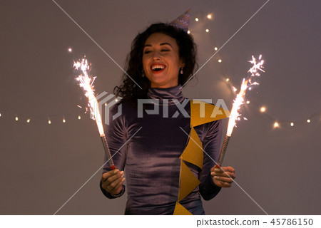Young happy woman with sparklers. Celebrate Christmas and New Year 45786150