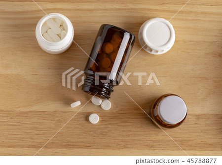 Different medicine bottles and round white pills Different medicine bottles and round white pills 45788877