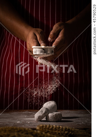 Chef spreading flour on bakery. Chef spreading flour on bakery. 45790529