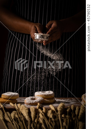 Chef spreading flour on bakery. Chef spreading flour on bakery. 45790532