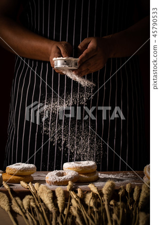 Chef spreading flour on bakery. Chef spreading flour on bakery. 45790533
