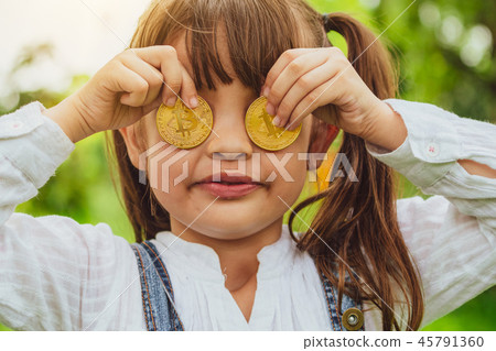 Little girl kid holding bitcoin digital money. Little girl kid holding bitcoin digital money. 45791360