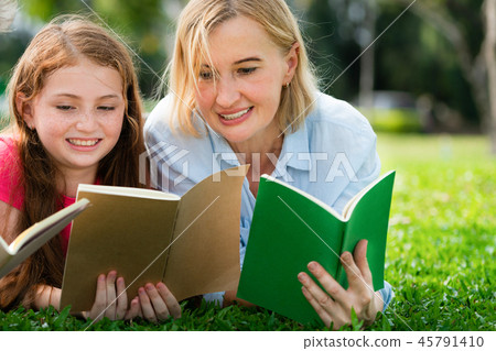 Happy family read books together in park garden. 45791410