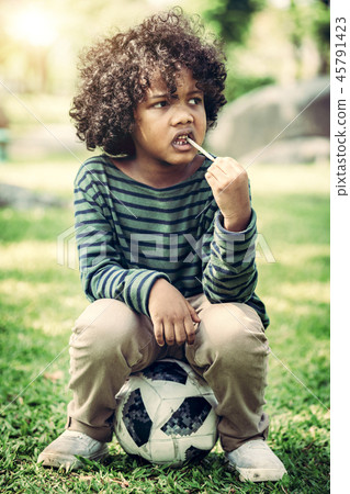 African american child eating snack stick. African american child eating snack stick. 45791423