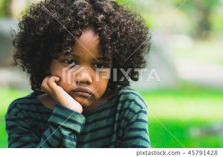 Unhappy little african american kid in the park. 45791428