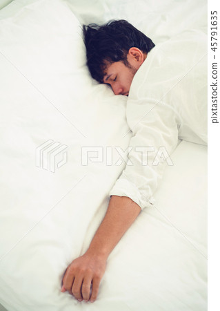 Young man sleep in bed in the bedroom. Young man sleep in bed in the bedroom. 45791635