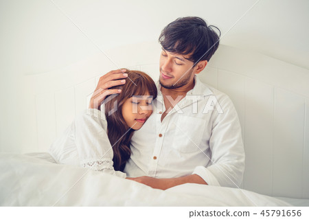 Happy young couple relaxing in the home bedroom. Happy young couple relaxing in the home bedroom. 45791656