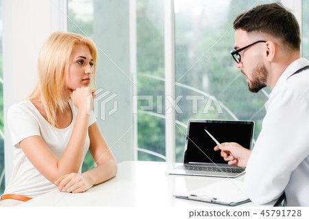 Male Doctor and Female Patient in Hospital Office 45791728