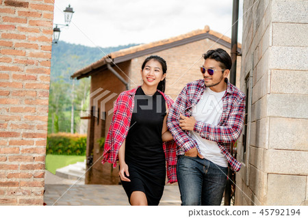Happy young couple walking on the street in town. 45792194