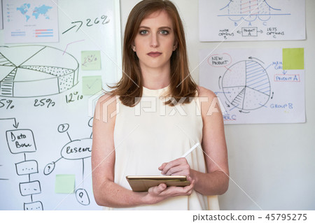 Serious businesswoman with tablet in office Serious businesswoman with tablet in office 45795275